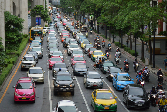Traffic scene depicting a congested street with various vehicles, including cars and motorcycles, emphasizing the importance of yielding right of way in driving.