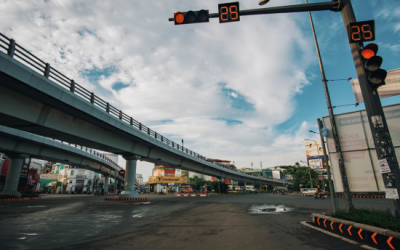 Traffic signal displaying countdown timer and speed limit sign at a busy intersection, illustrating key road safety elements relevant for driving tests.