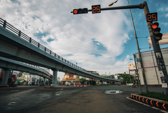Traffic signal displaying countdown timer at intersection with overpass, emphasizing road safety and traffic management.