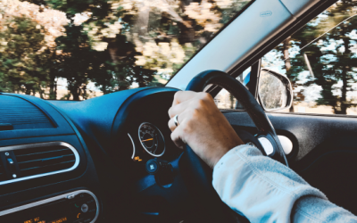 Driver's hand gripping steering wheel while navigating a vehicle, emphasizing safe driving techniques relevant to road test preparation.
