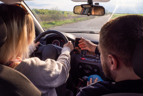 Person practicing driving with an instructor in a car, focusing on safe lane changes and road test preparation.