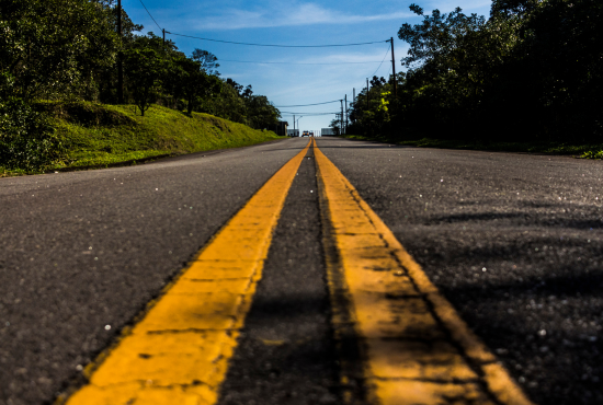 Road view showcasing yellow lane markings and clear skies, emphasizing practice routes for road test preparation.
