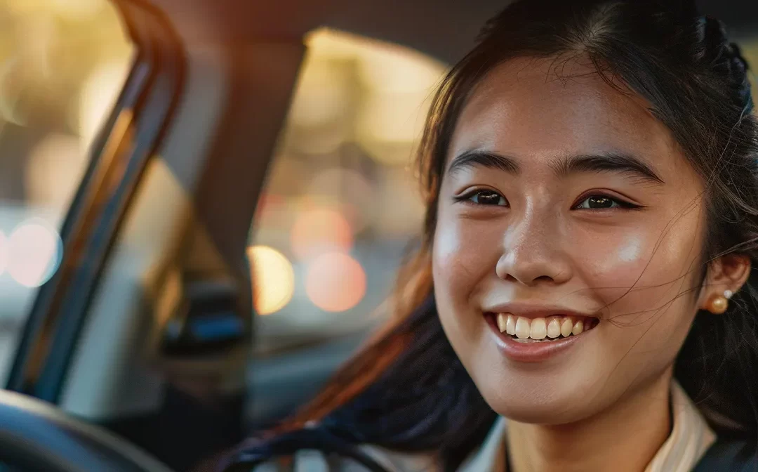 a person smiling and following an instructor's guidance while learning to drive in new york.