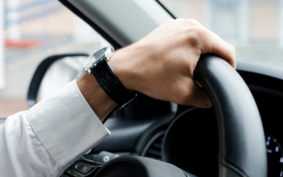 Driver's hand gripping steering wheel, emphasizing vehicle control for road test preparation.
