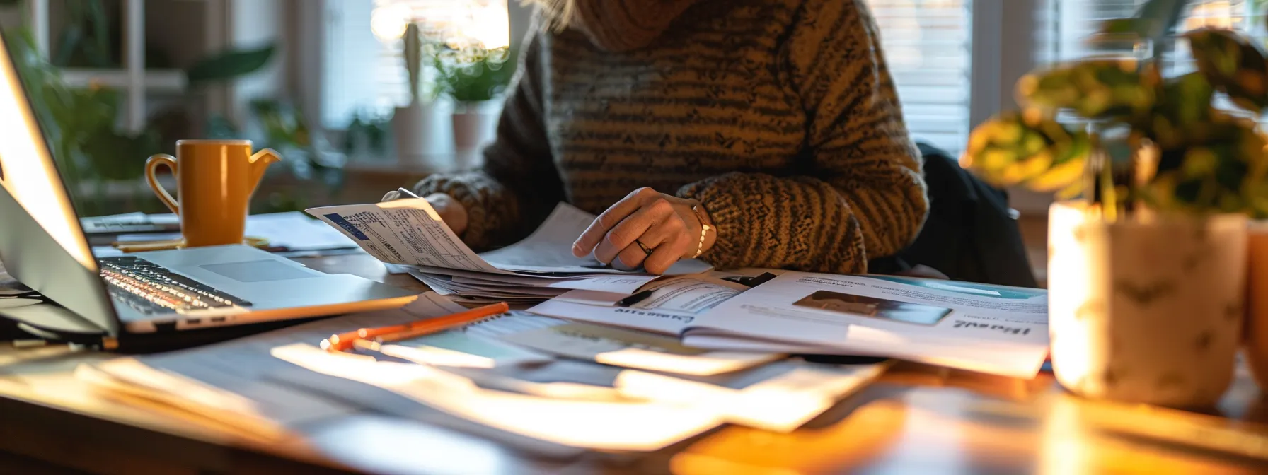a person sitting at a desk with a computer, surrounded by important documents and a credit card, preparing for the 5 hour pre licensing course online.